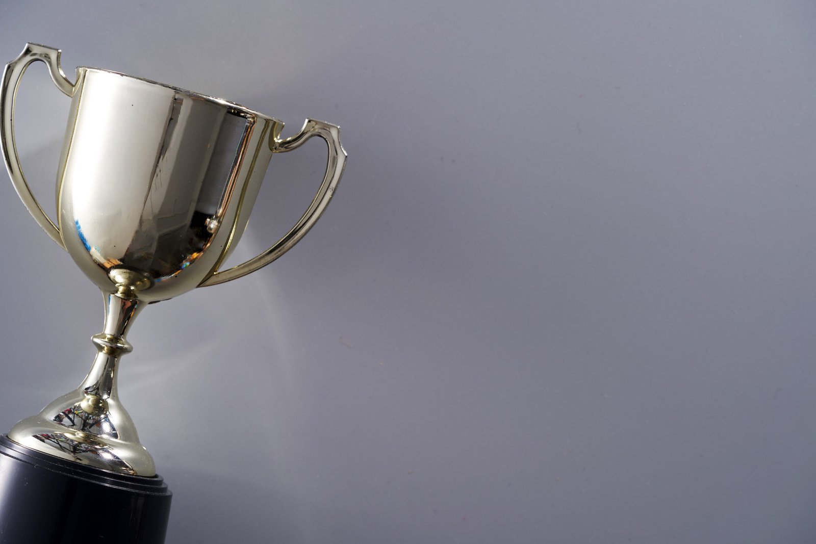 A shining trophy against a grey background.