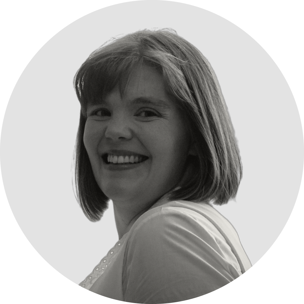 A black and white headshot of Charlotte Clewes-Boyne, a smiling white woman with a bob hair cut and fringe.