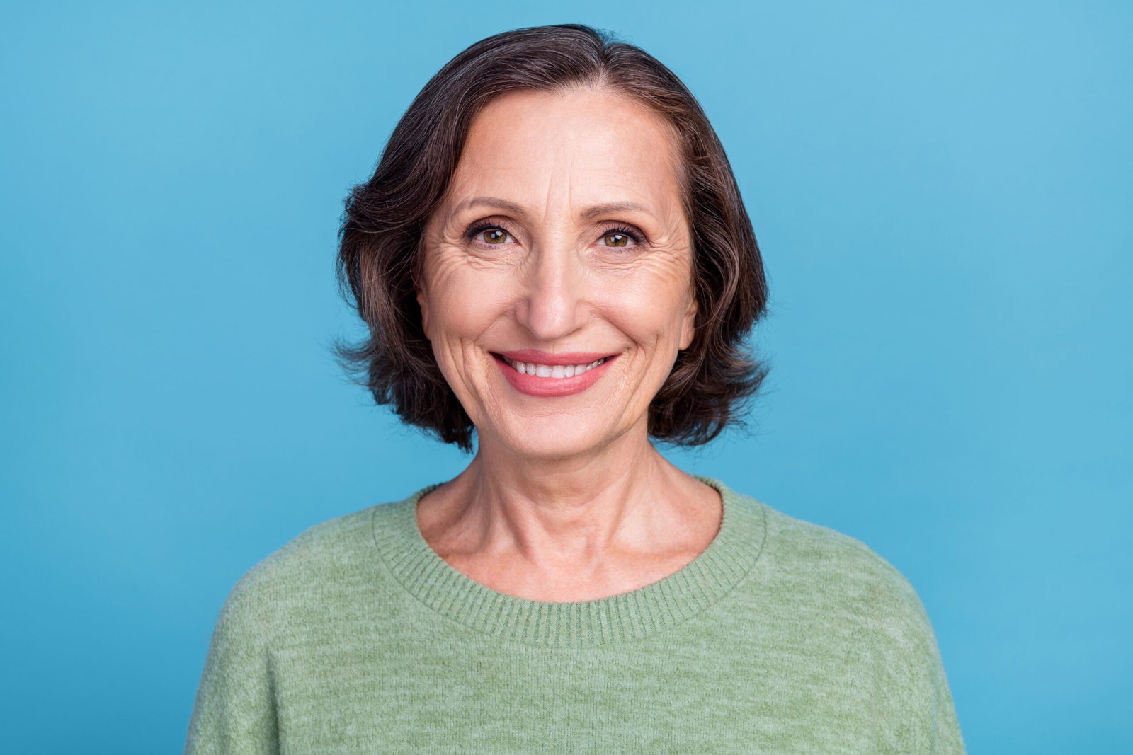 Headshot of grey-haired older white woman smiling with a bob haircut