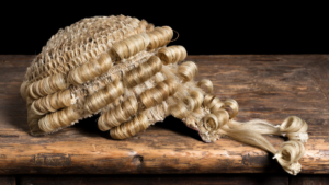 A horse-hair barrister's wig on a wooden desk